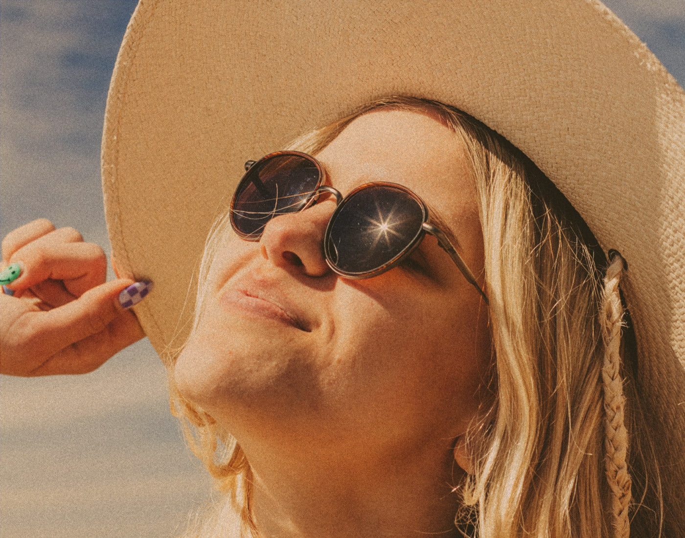 woman in hat basking wearing sunski baia sunglasses