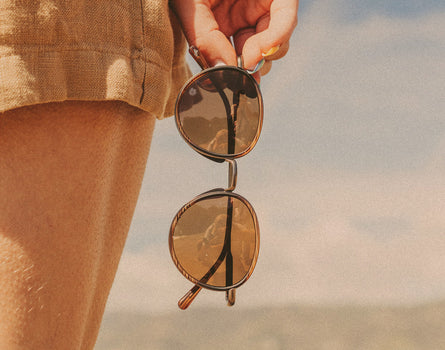 hand holding sunski baia sunglasses vertically