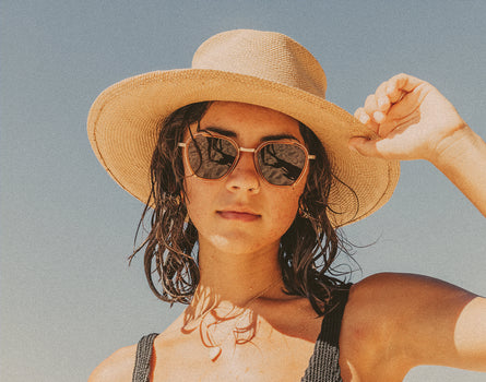 woman in a straw hat wearing sunski bernina sunglasses