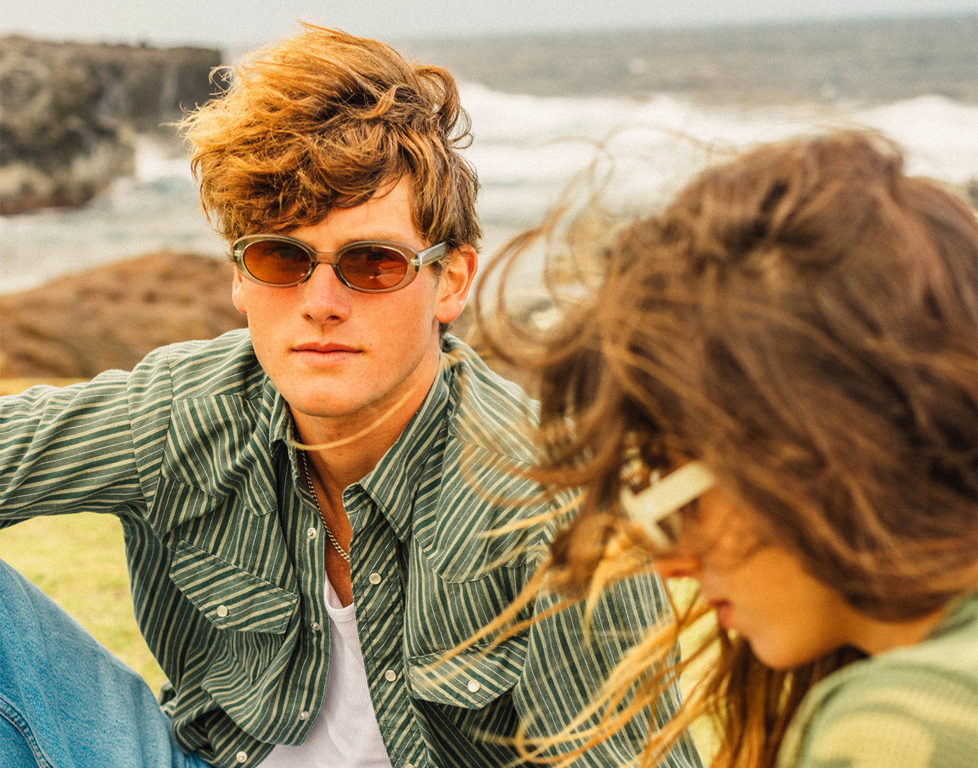 guy and girl sitting in grass wearing sunski bianca sunglasses