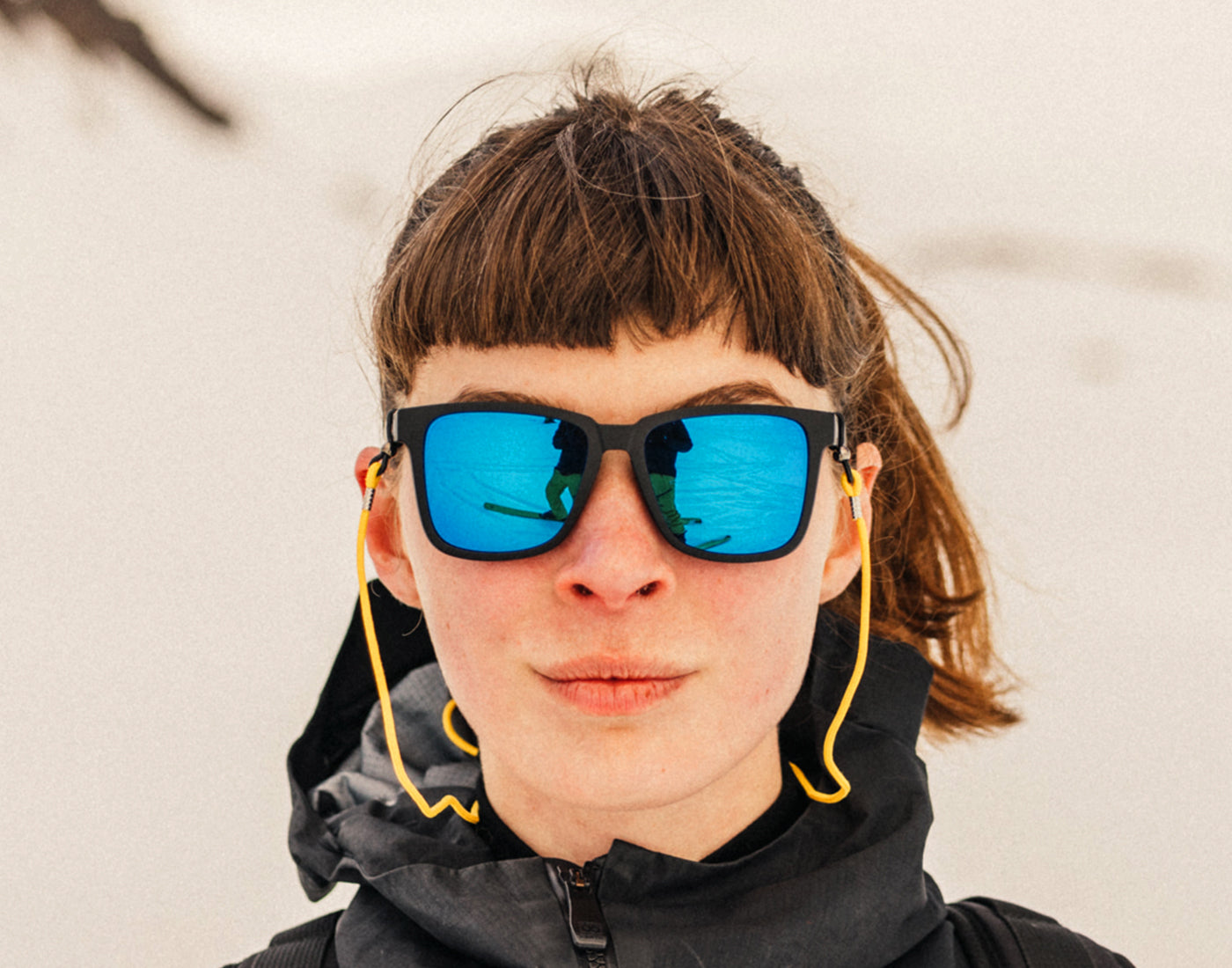 woman looking straight at the camera wearing sunski couloir sunglasses