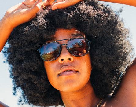 girl with hands on head wearing sunski estero sunglasses