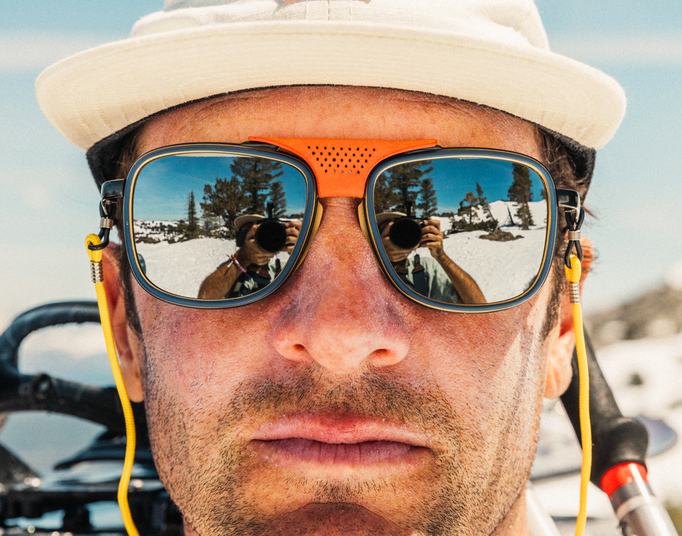 close up of man not smiling wearing sunski ferrata sunglasses