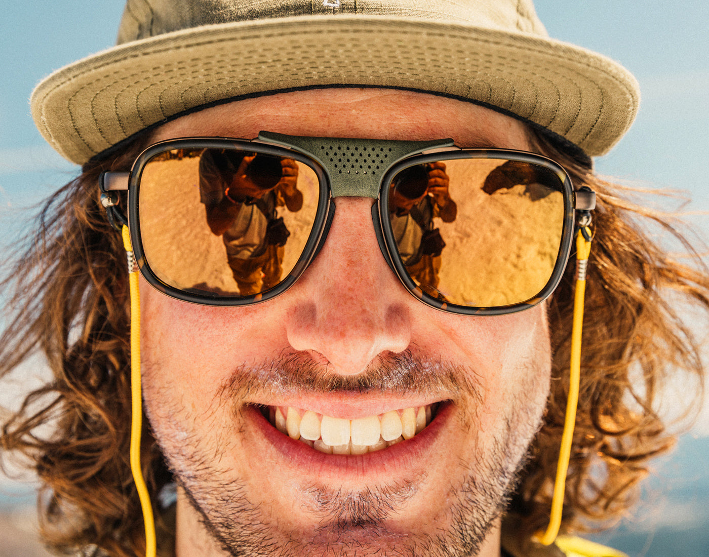 close up of man wearing a hat in sunski ferrata sunglasses