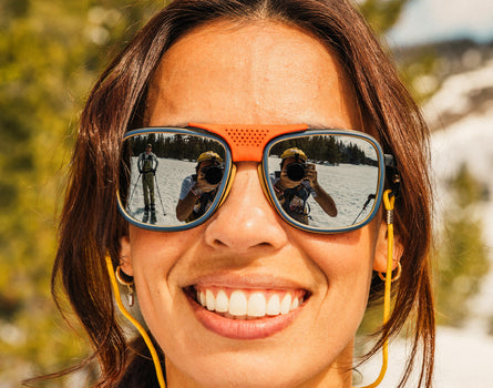 close up of girl smiling wearing sunski ferrata sunglasses