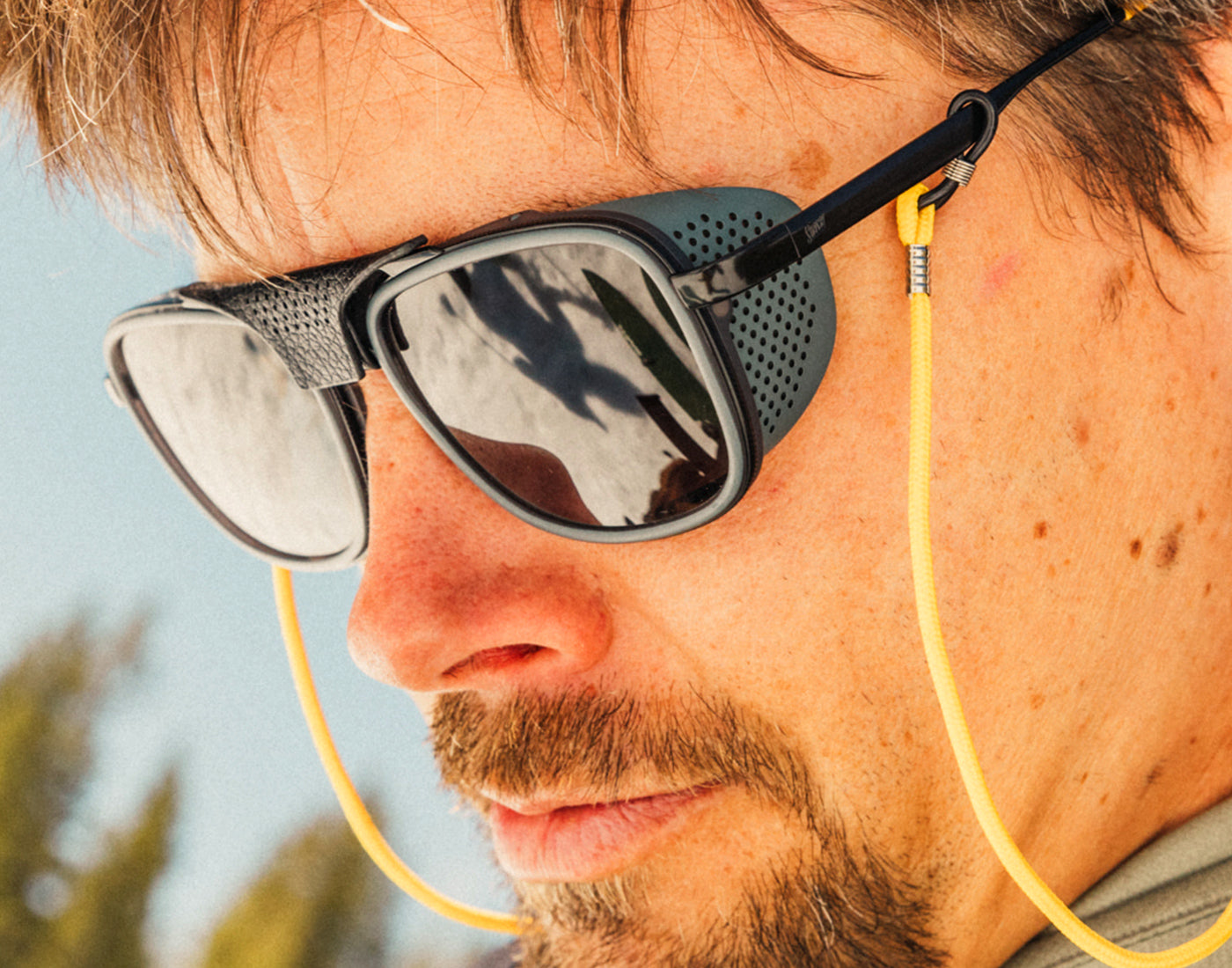 profile of guy looking down wearing sunski ferrata sunglasses