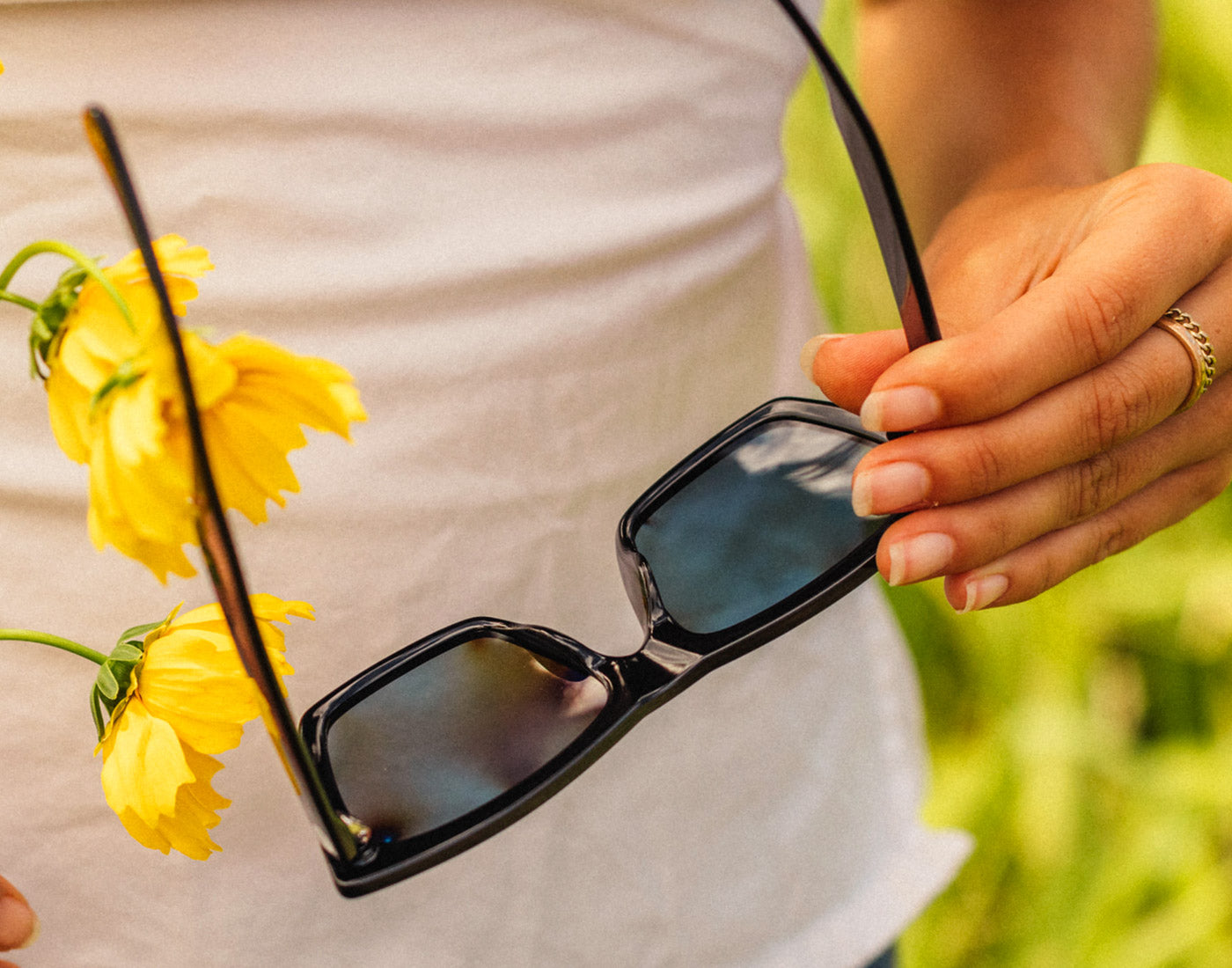 hand holding open pair of sunski fiorella sunglasses