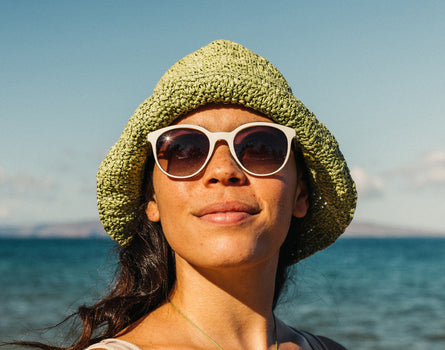 woman basking in a hat and sunski makani sunglasses
