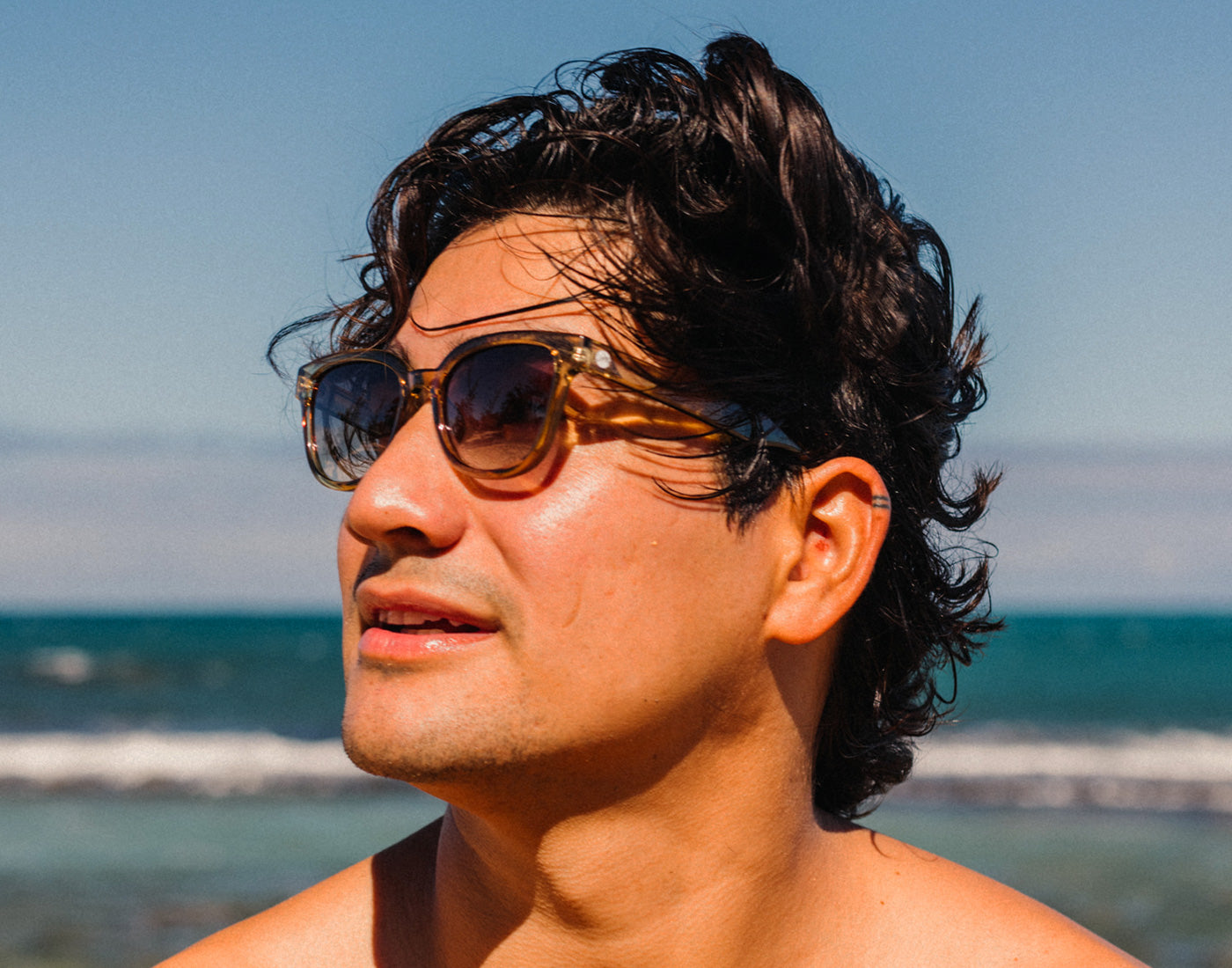 profile of man on beach wearing sunski miho sunglasses