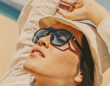 girl in hat basking in sunski shoreline sunglasses