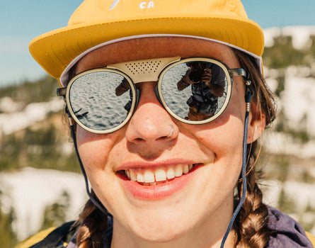 close up of girl smling in sunski hat wearing sunski strada sunglasses