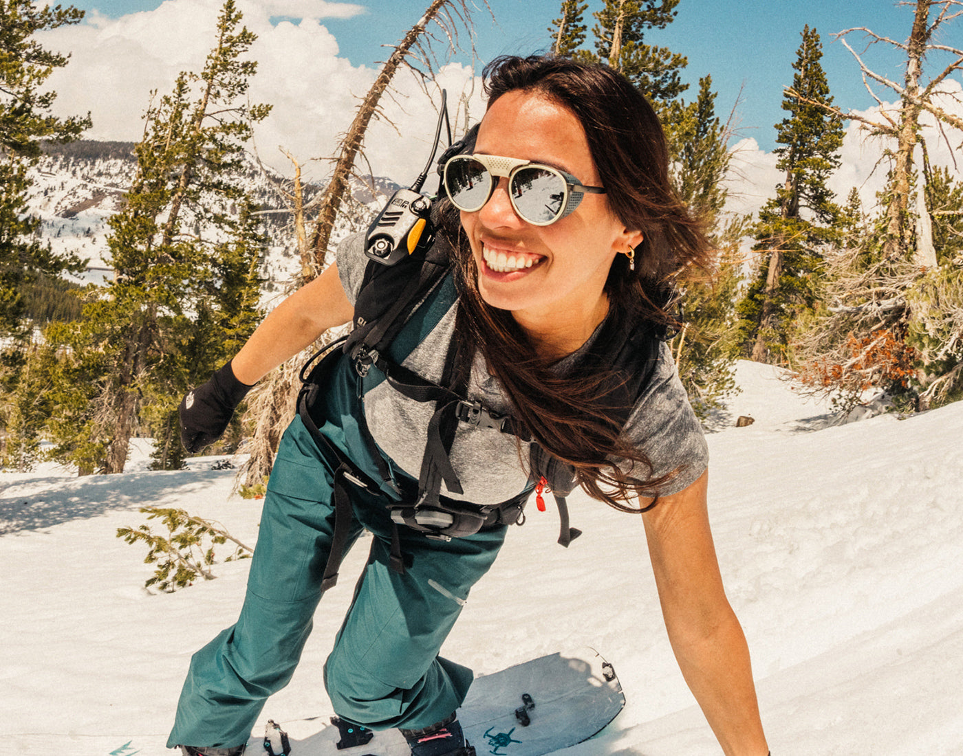 girl snowboarding wearing sunski strada sunglasses