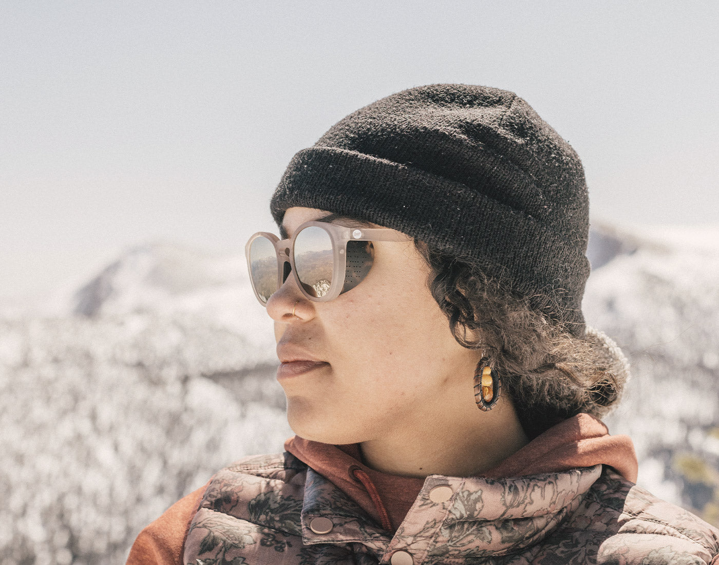 profile of girl in a beanie wearing sunski tera sunglasses