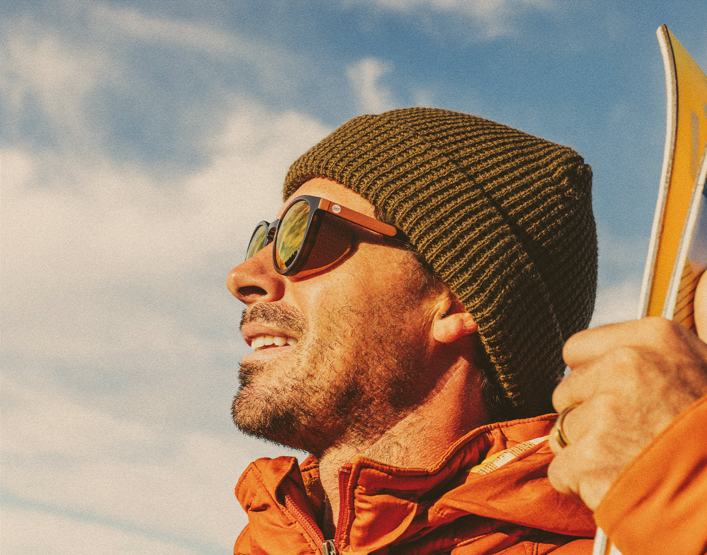 profile of man wearing a beanie and sunski tera sunglasses