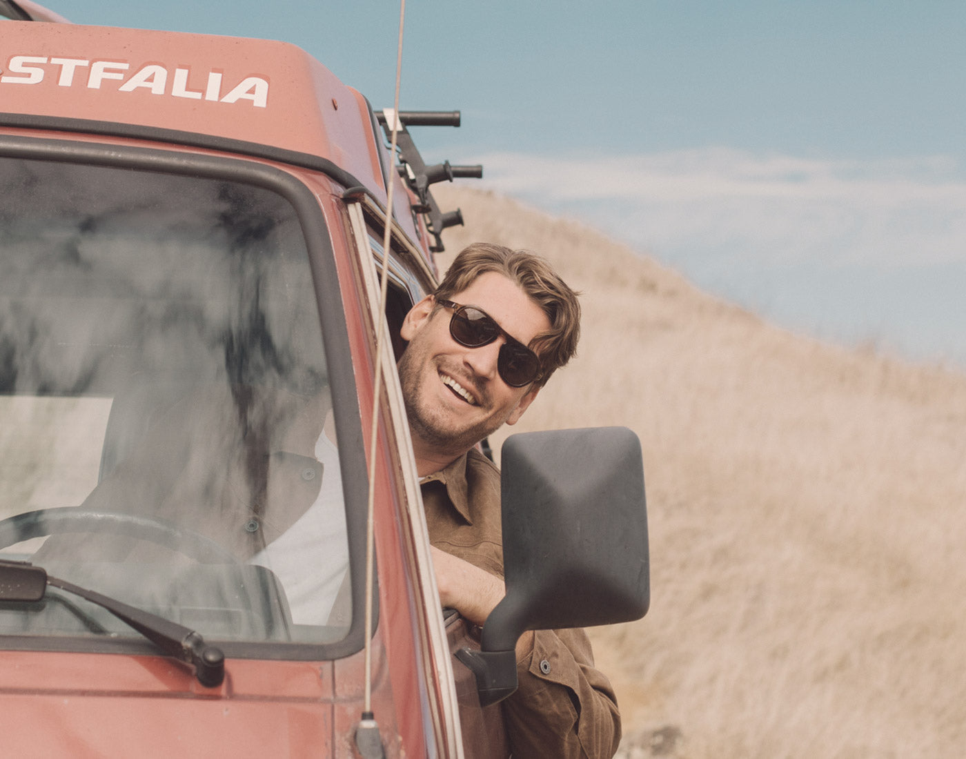 guy sticking his head out of a car window wearing sunski treeline sunglasses