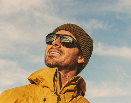 man looking up at sky wearing sunski treeline sunglasses