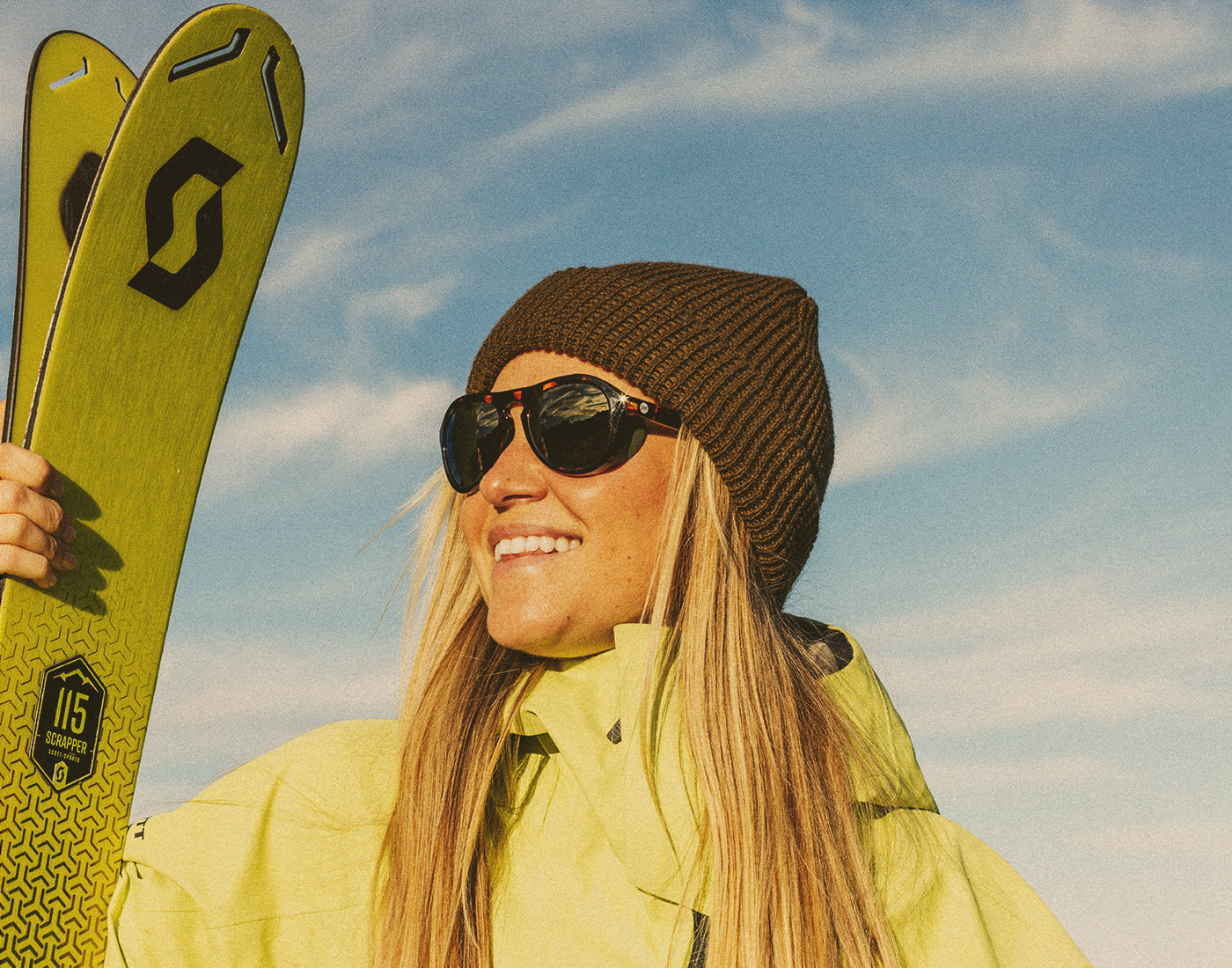 woman holding skis wearing sunski treeline sunglasses