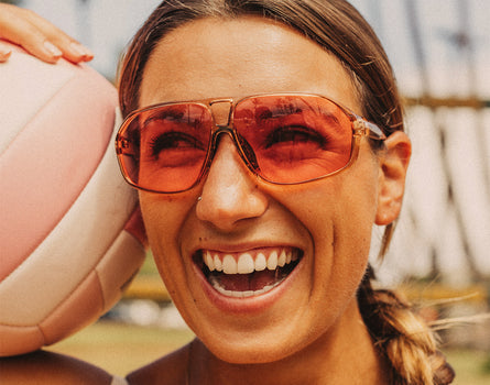 girl with volleyball laughing wearing sunski velo sunglasses