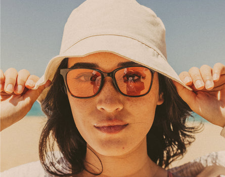 woman in a hat wearing sunski ventana polarized sunglasses