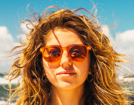 girl with wind blown hair 
wearing sunski yuba sunglasses