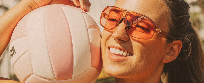 girl holding volleyball wearing sunski velo sunglasses