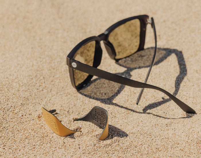 STORY sunski couloir sun shields laying in the sand next to couloir sunglasses