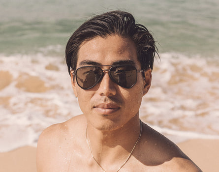guy at the beach wearing sunski astra sunglasses