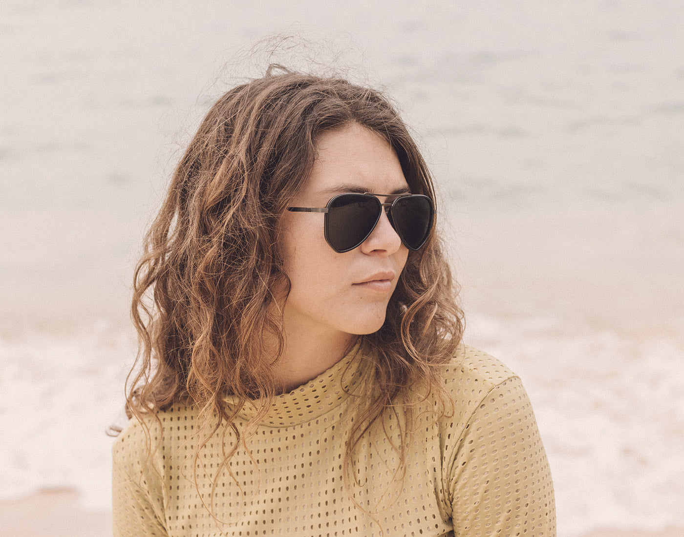 profile of girl on the beach wearing sunski astra sunglasses