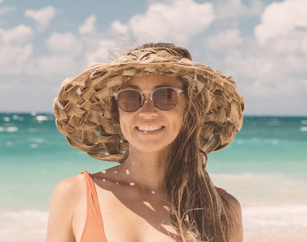 girl in big hat wearing sunski avila sunglasses