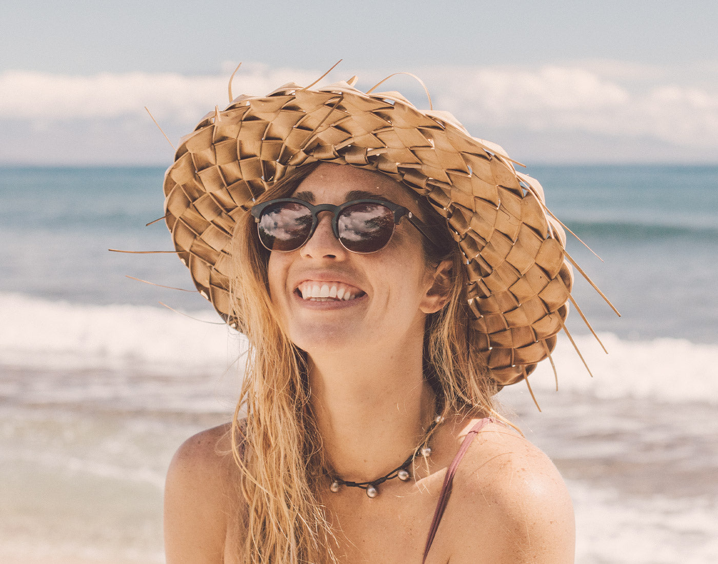 girl in hat laughing wearing sunski avila sunglasses