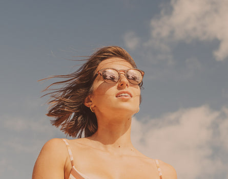 girl in the wind wearing sunski avila sunglasses