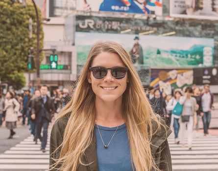 girl in a city wearing sunski avila sunglasses