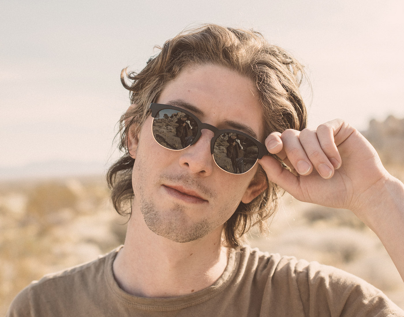 guy holding sunski avila sunglasses up to face