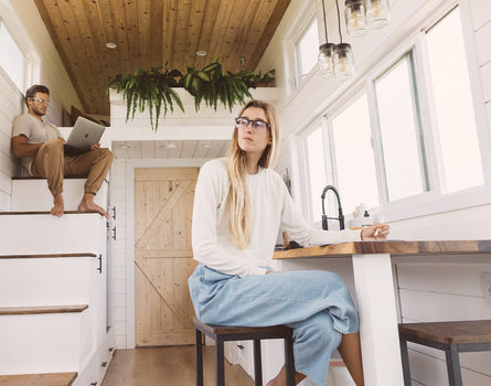 man and woman in tiny home wearing sunski avila bluelight glasses