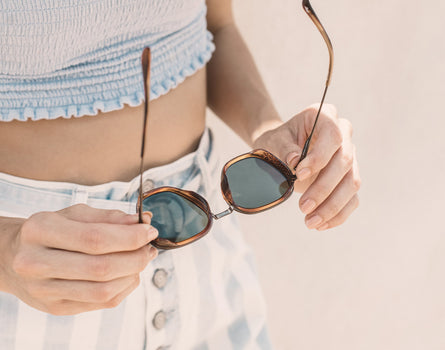 hands holding unfolded sunski bernina sunglasses