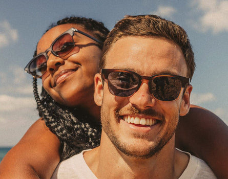 girl on guy's back wearing sunski cambria sunglasses