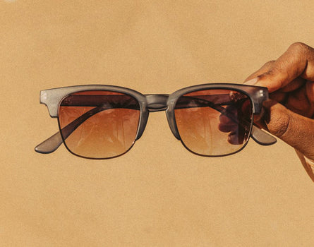 hand holding sunski cambria navy amber sunglasses