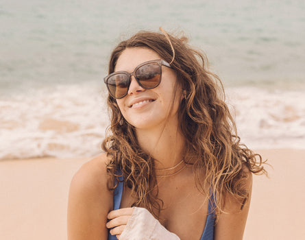 girl on the beach laughing wearing sunki camina sunglasses
