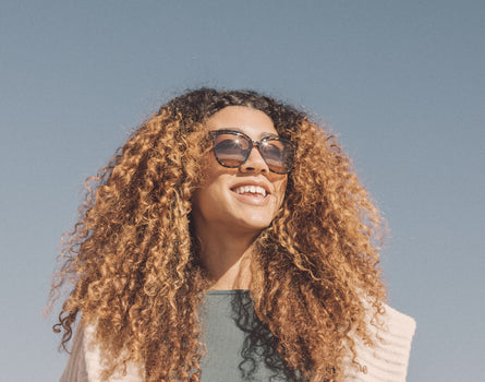 low angle of a girl laughing wearing sunski camina sunglasses