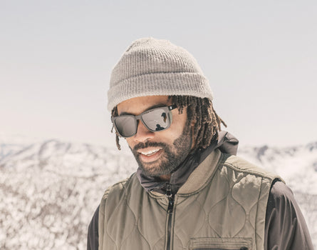 guy in a beanie looking down wearing sunski couloir sunglasses