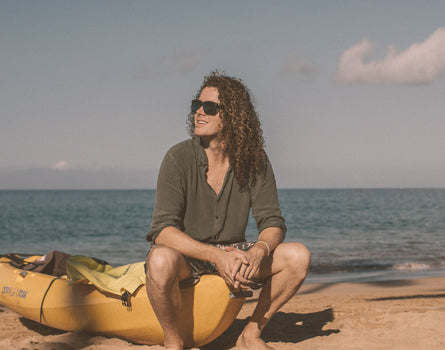 guy sitting on edge of kayak wearing sunski couloir sunglasses