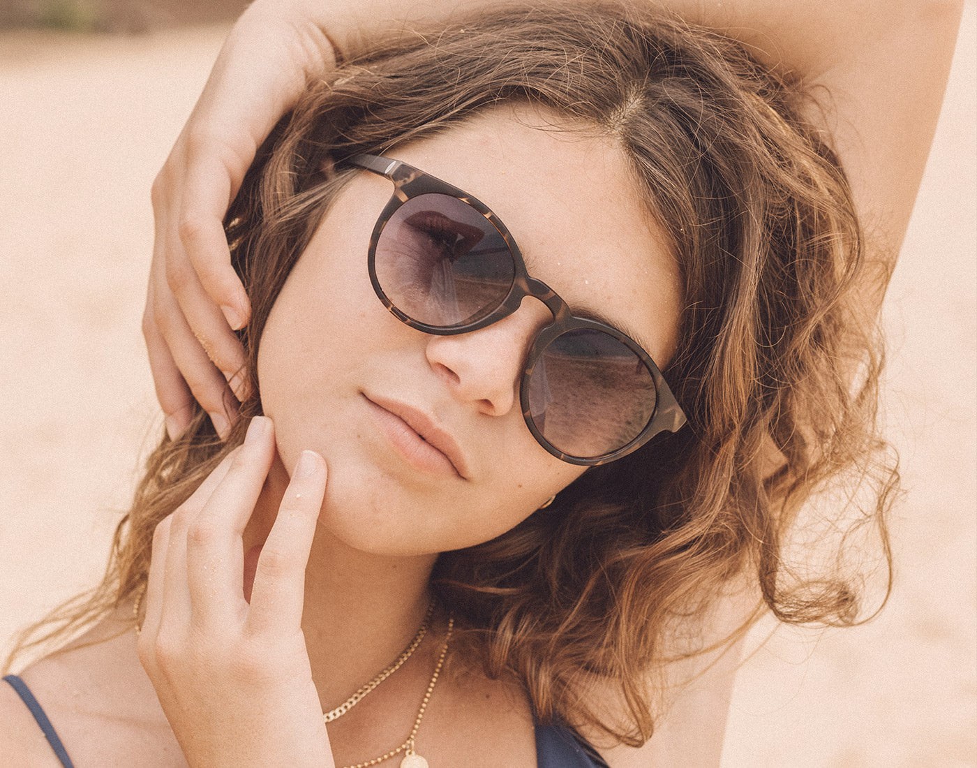 girl with hand on head wearing sunski dipsea sunglasses