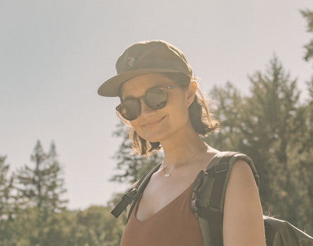 girl smiling and hiking wearing sunski dipsea sunglasses