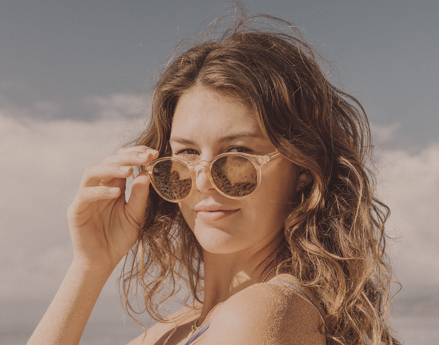 girl holding sunski dipsea sunglasses on face
