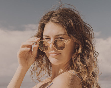 girl holding sunski dipsea sunglasses on face