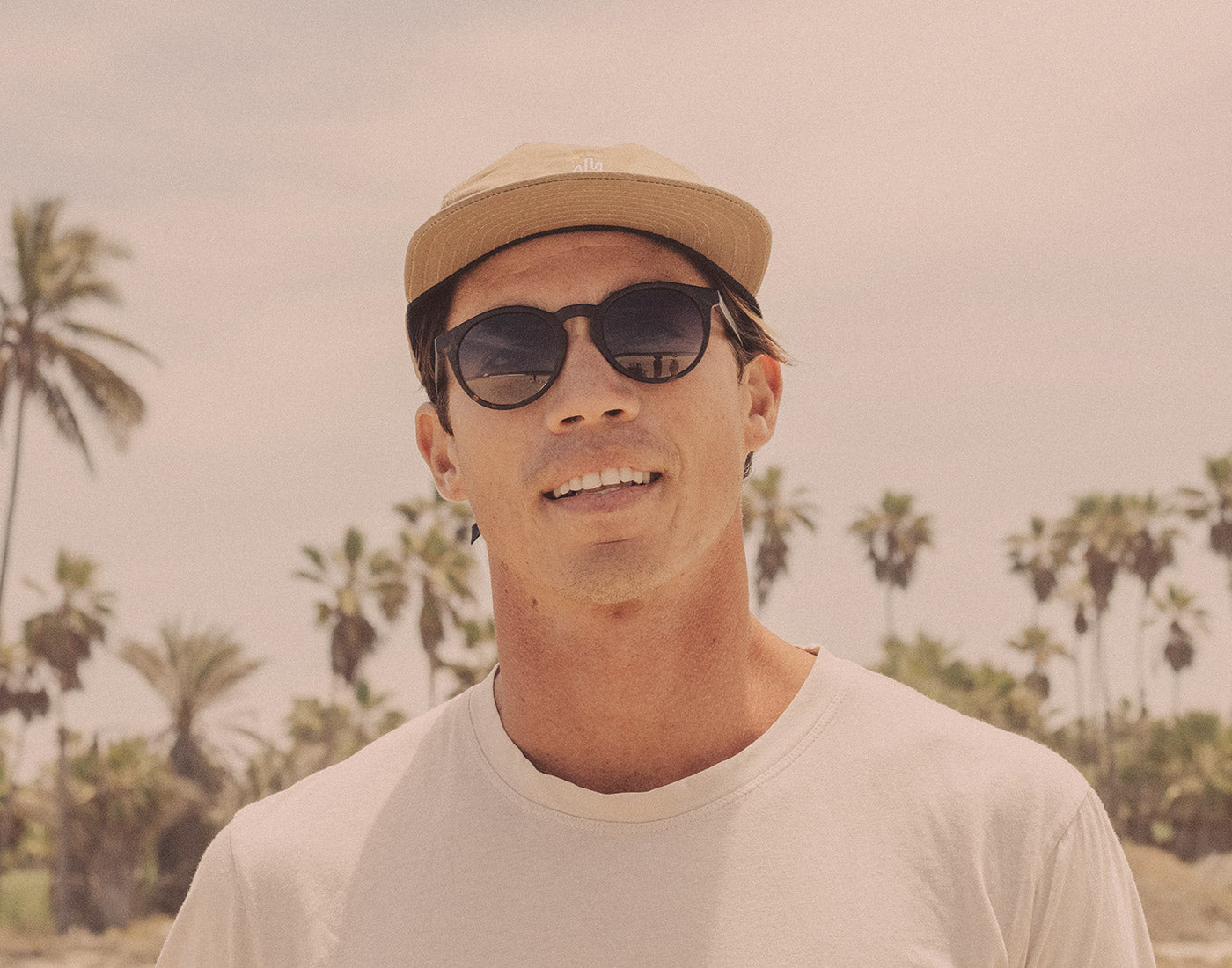 guy in a hat wearing sunski dipsea sunglasses