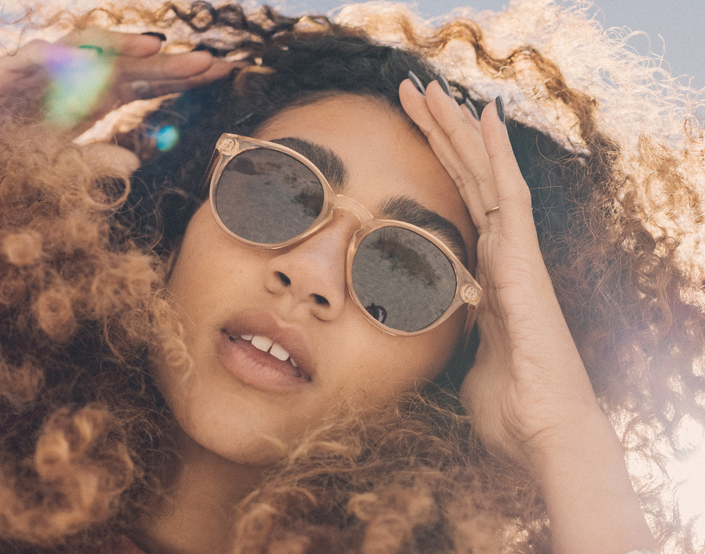 girl holding hair out of her face wearing sunski dipsea sunglasses