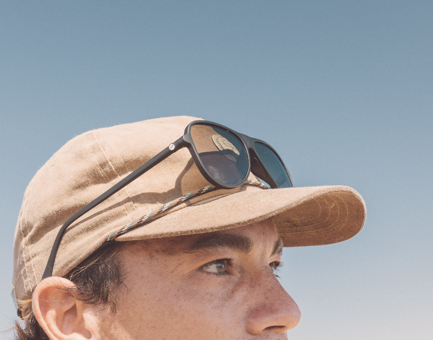 profile of guy with sunski foxtrot sunglasses on hat