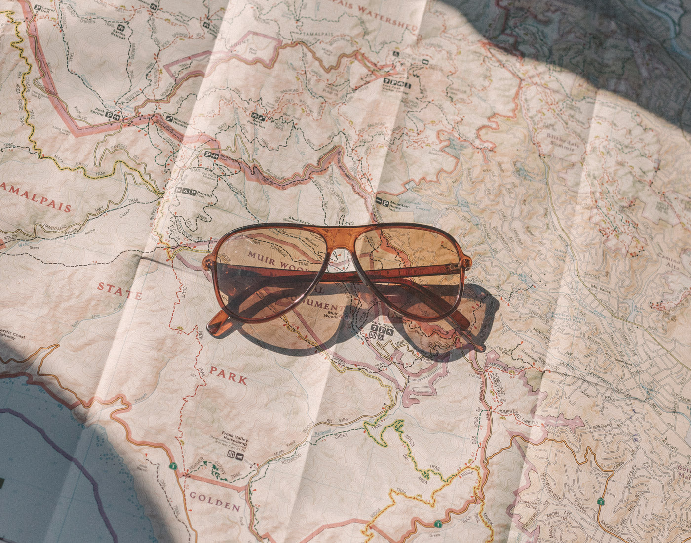 sunski foxtrot sunglasses laying on a map