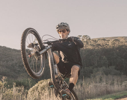 guy popping a wheely on a bike wearing sunski foxtrot sunglasses